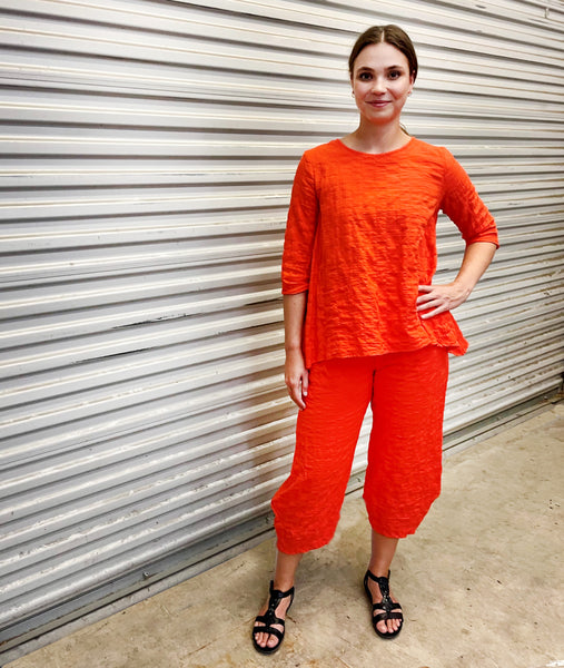 model in a chili orange pant with a matching top