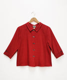 boxy crimson button down top with a twin button detail along the front, back and sleeve cuffs