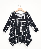 black jersey top with a white brushstroke print. top has long sleeves, a wide rounded neckline, and dips in the hem at each side in front and back