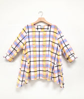 multicolor plaid pullover top with dips at the sides of each hem, rolled long sleeves and a round neckline