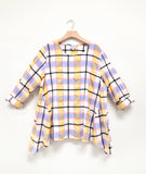 multicolor plaid pullover top with dips at the sides of each hem, rolled long sleeves and a round neckline