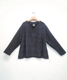 grey and black striped top with long sleeves, a vneck, and a straight hem, longer in the back with a split at each side