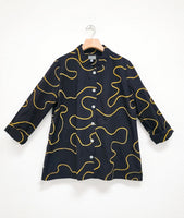 black cotton button down with a yellow swirl embroidered all over. blouse has long sleeves rolled up and a white cateye button