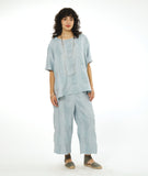 model in a silvery blue large grid print wide leg pant with a matching pullover top with a raglan sleeve