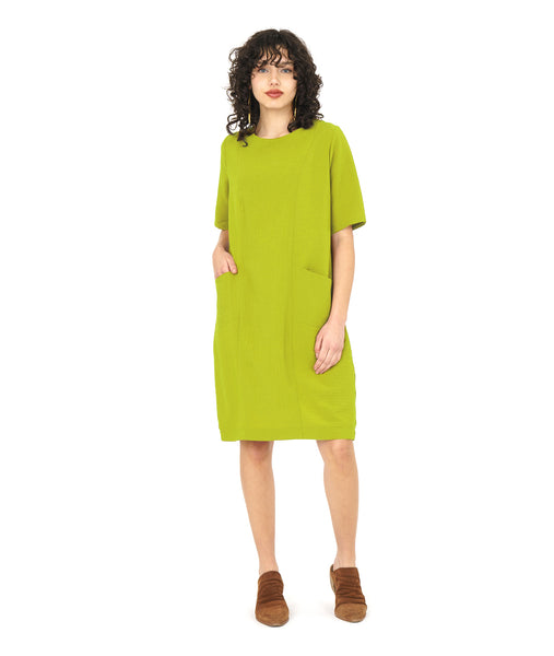 model in a lime shift dress with princess seams and angled hip pockets