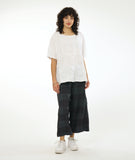 model in a dark grey large grid print wide leg pant with a matching white pullover top with a raglan sleeve