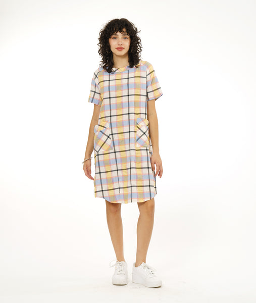 model in a short pullover dress in a multi-color plaid print. dress has contrasting hip pockets, short raglan sleeves and a cowl neck