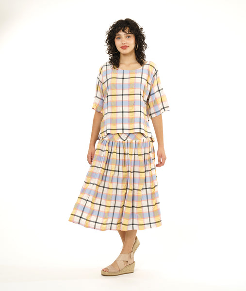 model in a multi-color plaid boxy pullover top with a matching skirt with a dropped waist