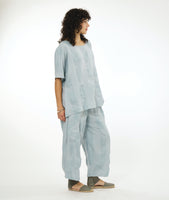 model in a silvery blue pullover top with a matching wide leg pant with an oversized pocket and tapered ankle