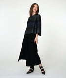 model in a wide leg black pant with a striped blue boxy top with a full body and sleeve. fabric for top is striped in varying shades of blue