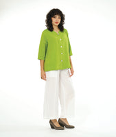 model in a wide leg white pant with a boxy lime button down blouse with a 3/4 sleeve and a small meandering collar