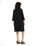 model in a black shirt dress with elbow length sleeves and black twin buttons half way down the dress front center