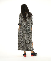 model in a black and white print straight leg pant with a matching button down blouse with a wide rounded collar and a 3/4 sleeve