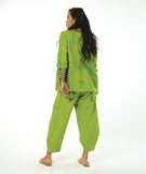 model in a wide leg lime green pant with a tapered ankle, worn with a matching pullover top with a single hip pocket, 3/4 sleeves, a dipped him at either hip and a rounded neckline. Top has an extra large grid print woven in to it