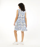 model in a sleeveless button down shirt dress in white with a black and blue leaf print