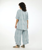 model in a silvery blue pullover top with a matching wide leg pant with an oversized pocket and tapered ankle