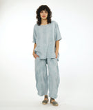 model in a silvery blue pullover top with a matching wide leg pant with an oversized pocket and tapered ankle
