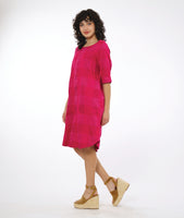 model in a pink extra large check print pullover dress with a rounded neckline, elbow length sleeves and a rounded hemline 