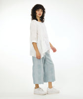 model in a large grid print silvery blue wide leg pant, with a matching white pullover top with a dipped hem on either side, 3/4 sleeves and a single hip pocket
