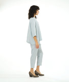 model in a slim cropped silvery blue pant with a boxy matching button down blouse with a 3/4 sleeve and a small meandering collar