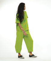 model in a wide tulip shaped lime green pant with a tapered ankle, worn with a matching top in a extra large grid print with a round collar, short sleeves, two squared hip pockets and a buttoned packet up the back