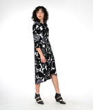 model in a black and white circle print dress with a twist detail at the hip