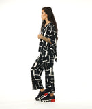 model in a black and white brushstroke print top with v-neck, 3/4 sleeves and a matching straight leg pant