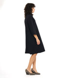 model in a black shirt dress with elbow length sleeves and black twin buttons half way down the dress front center