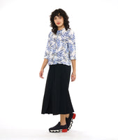 model in a wide leg black pant with a front apron overlay, worn with a white button down blouse with a boxy body, 3/4 sleeves and a blue and black leaf print