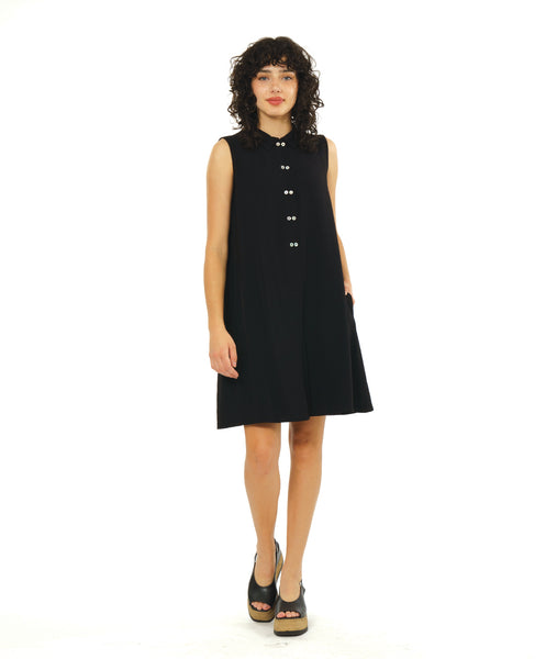 model in a sleeveless shirt dress in black with a half placket of twin buttons