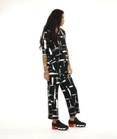 model in a black and white brushstroke print top with v-neck, 3/4 sleeves and a matching straight leg pant