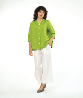 model in a wide leg white pant with a boxy lime button down blouse with a 3/4 sleeve and a small meandering collar