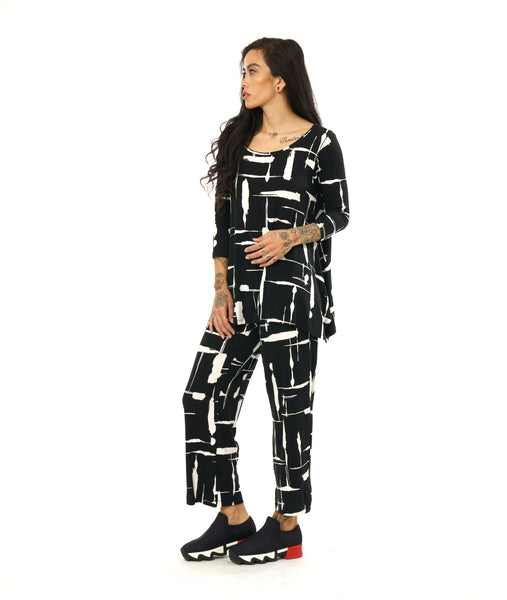 model in a black and white print jersey tee with a 3/4 sleeve, rounded neckline and dipped hem on either hip, worn with a matching straight leg pant