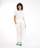 boxy white pullover top with a matching white pant with a wide leg and deep vertical tucks at the waist