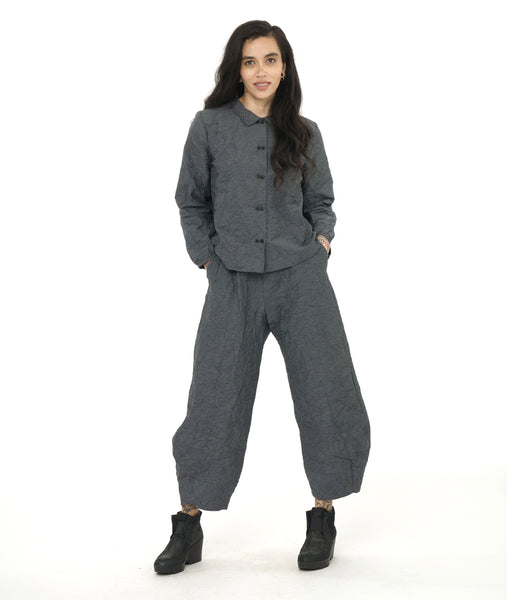 model in a grey and black textured pinstipe button down blouse with long sleeves, worn with a matching wide leg pant 