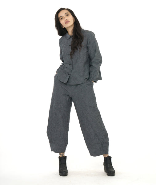 model in a grey and black textured pinstipe button down blouse with long sleeves, worn with a matching wide leg pant