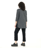 model in a grey and black pinstripe tunic length top with squared hip pockets, 3/4 sleeves and large round buttons down the placket, worn with a black slim pant