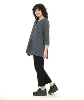 model in a grey and black pinstripe tunic length top with squared hip pockets, 3/4 sleeves and large round buttons down the placket, worn with a black slim pant