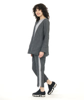 model in a grey and black textured pinstipe top with a contrasting panel in the front in a grey and white stripe. worn with a matching pant with a contrasting tuxedo stripe on the side