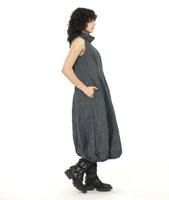 model in a black and grey pinstripe sleeveless dress with a crush texture. dress has an oversized cowl neck, tucks at the front and back waist, and an elastic gathering at the bottom hem creating a tulip shaped skirt