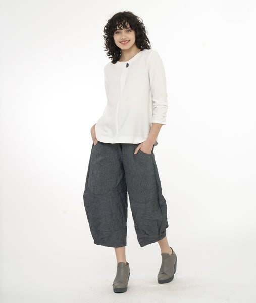model in a grey and black pinstriped wide leg pant, with oversized pockets, worn with a white pullover top