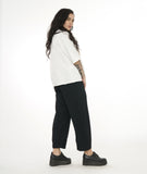 model in a wide leg black textured pant, worn with a textured white pullover top with a short standing collar and 3/4 length raglan sleeves