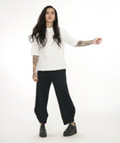 model in a wide leg black textured pant, worn with a textured white pullover top with a short standing collar and 3/4 length raglan sleeves