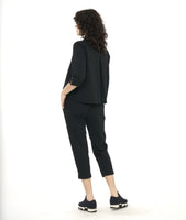 model in a black textured boxy button down blouse with a matching crop pant. blouse has a twin button detail and 3/4 sleeves with a split cuff