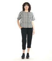 model in a short boxy plaid top with a textured black crop pant