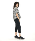 model in a short boxy plaid top with a textured black crop pant