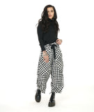 model in a black mock turtleneck top, worn with a textured black and white plaid print wide leg pant with a tapered ankle, oversized exterior pockets, and a black tie belt over the elastic waistband