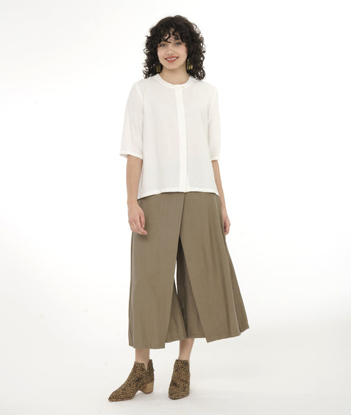 model in a wide leg taupe pant with a white boxy top with 3/4 sleeves and a hidden placket