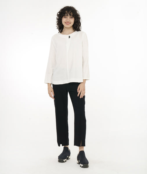 model in a slim black pant worn with a white pullover top with long sleeves, a round hem and round neckline with a triangle placket and button detail