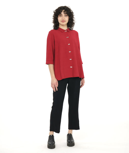 model in a slim black pant with a crimson red long button down blouse with 3/4 sleeves, with a twin button detail on the placket and sleeve cuffs
